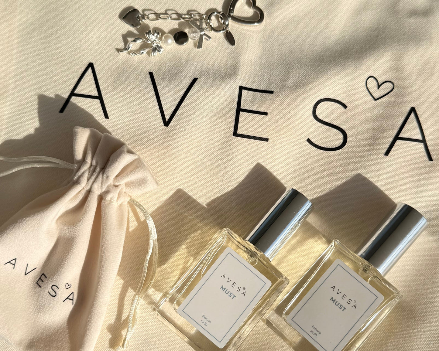 לוגו AVESA ותיק קטיפה עם לוגו ושני בשמים במראה מואר